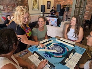 Students learning American MahJong at a table